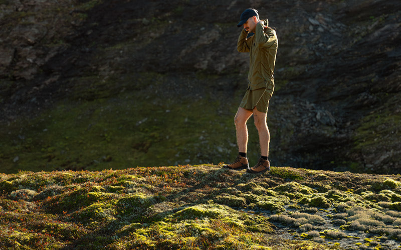 Person in outdoor clothing standing on a rocky landscape