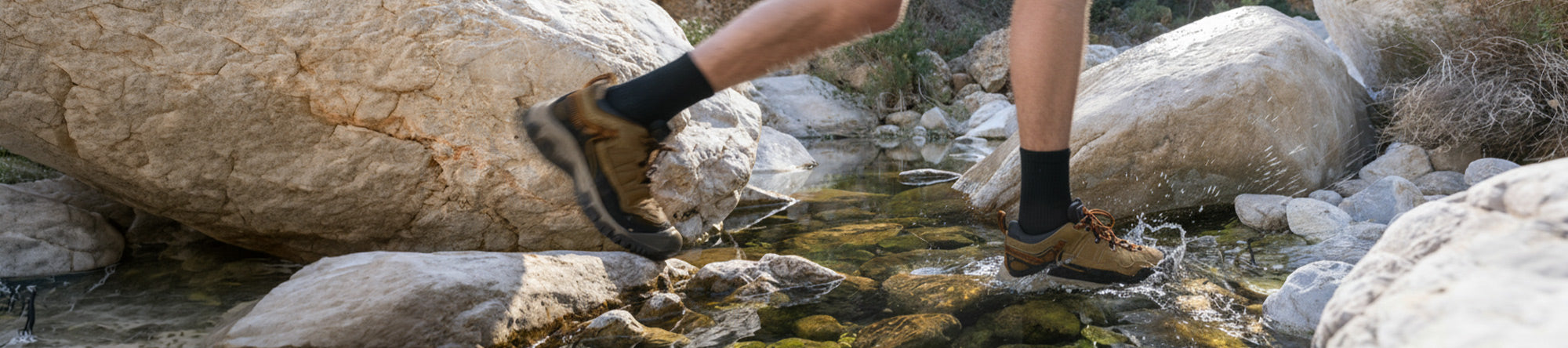 Person wearing hiking boots stepping onto a rock in a natural setting
