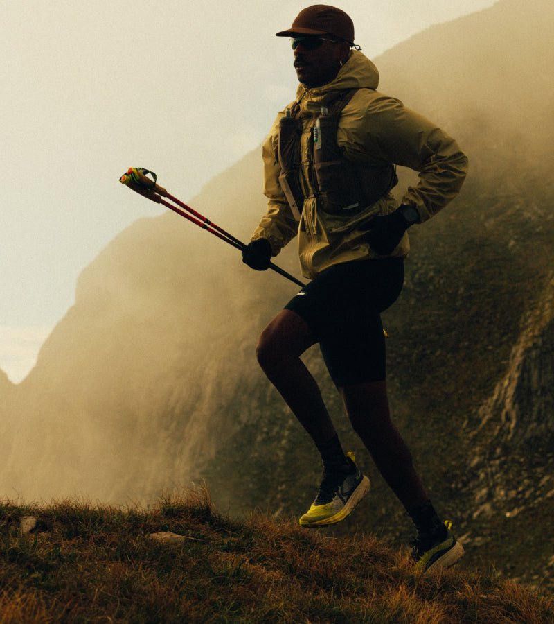 Person hiking on a mountain trail with hiking poles
