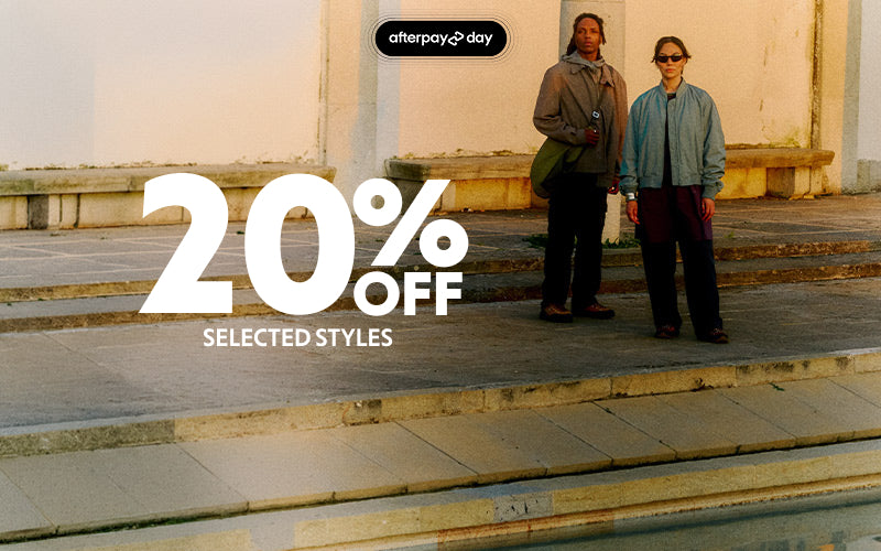 A promotional banner featuring two models standing on stone steps in front of a building, with large white text reading '20% OFF SELECTED STYLES' and an 'afterpay day' badge at the top.