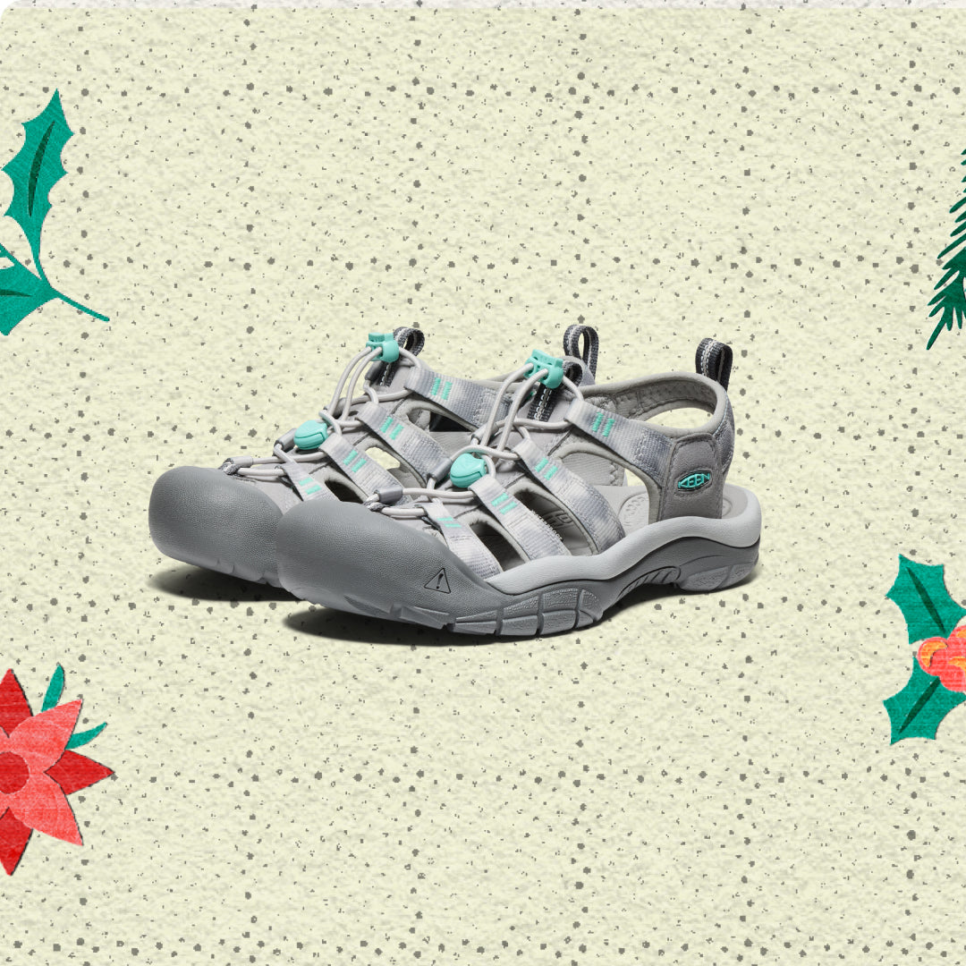 Gray sandals on a beige background with holly leaf and flower decorations