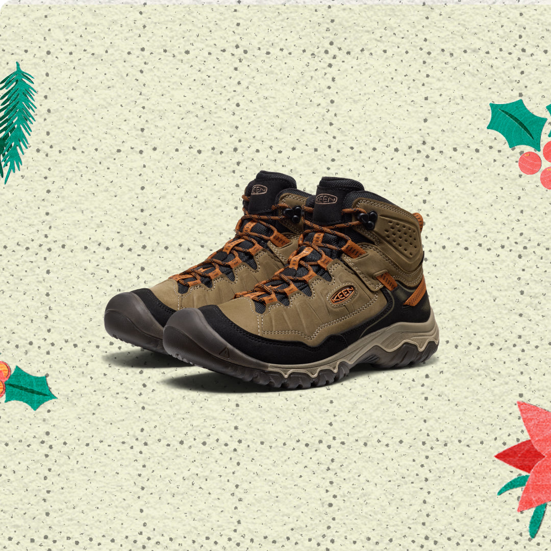 Pair of brown hiking boots on a textured beige background with decorative elements.