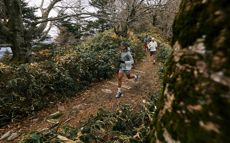 Person running on a trail in a forested area