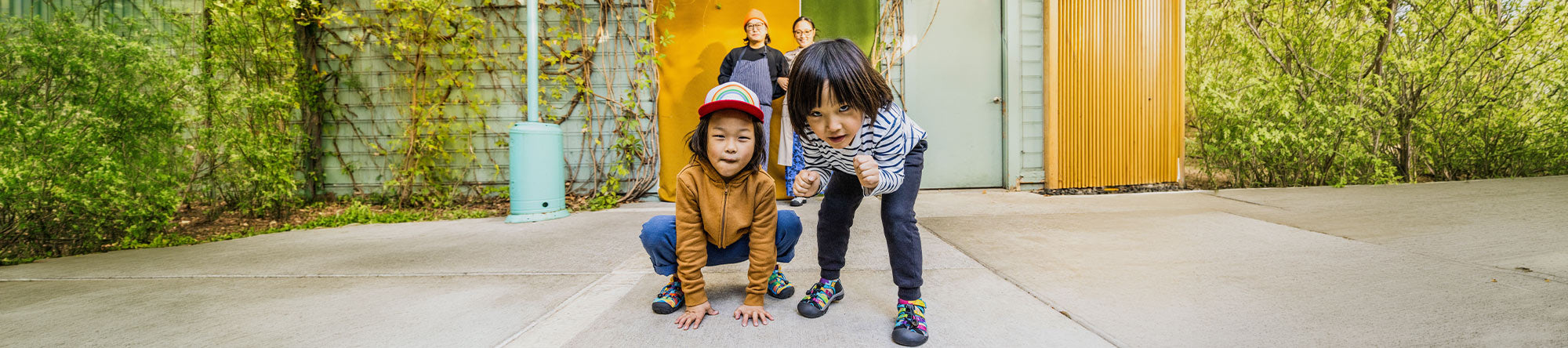 Two children playing with a baseball bat and glove on a concrete surface.