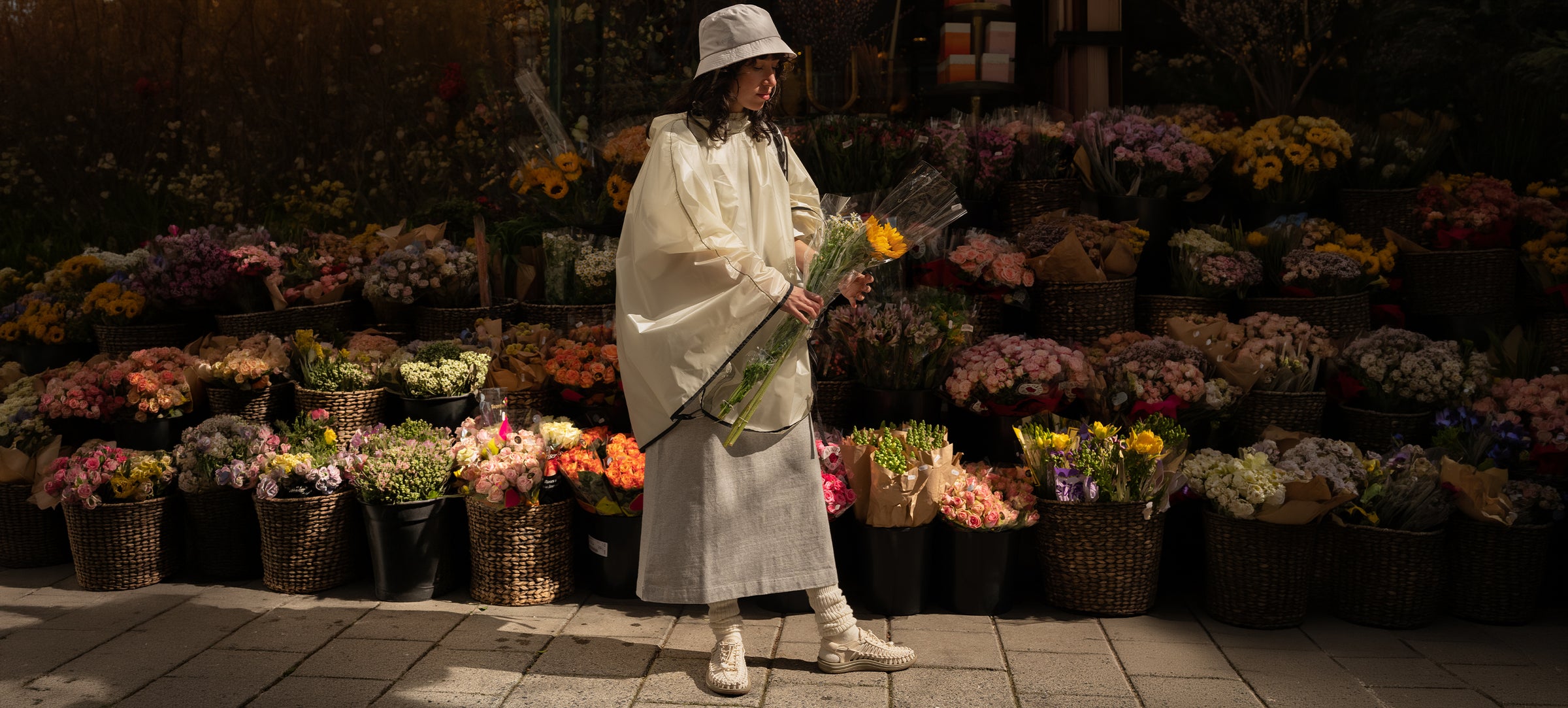 Person holding flowers in a flower market at night