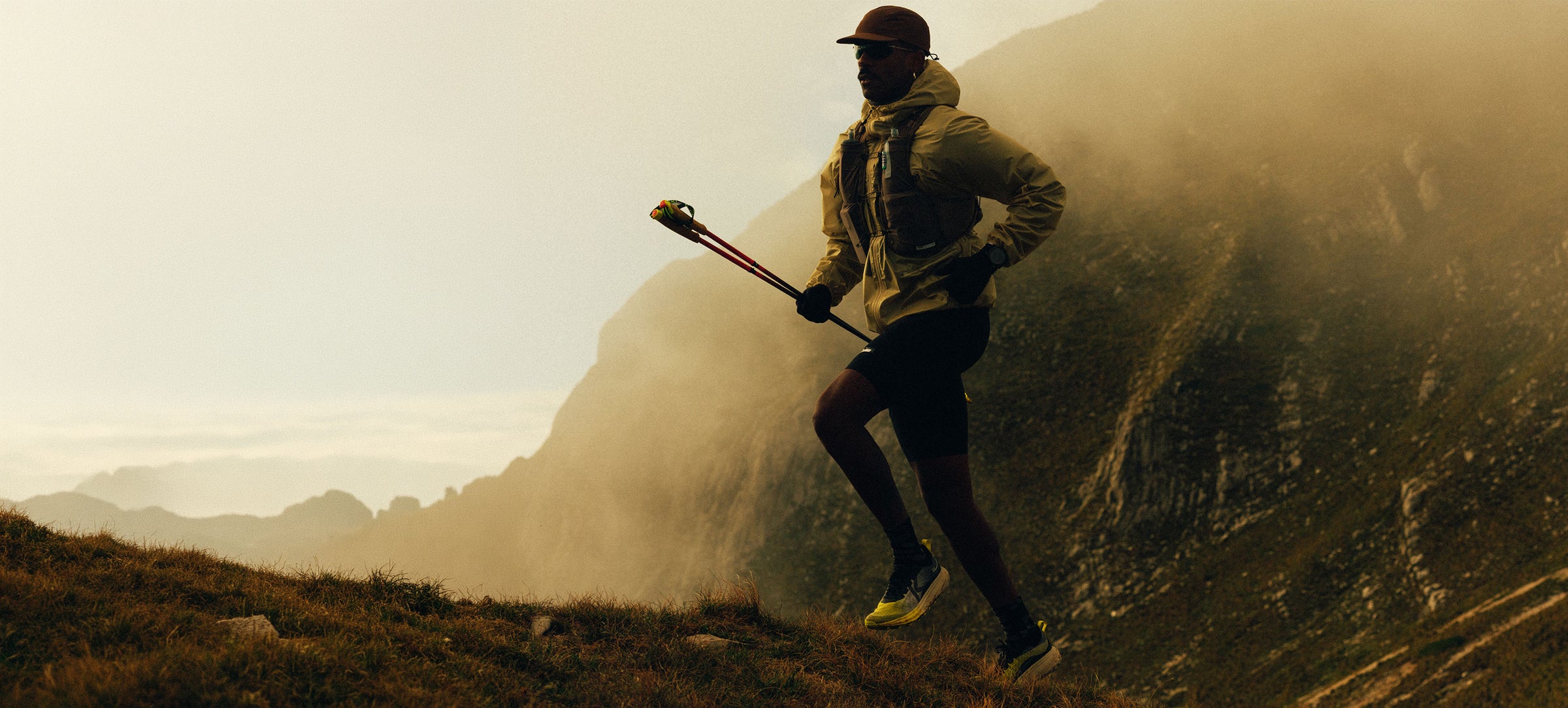 Person running on a mountain trail with a scenic background