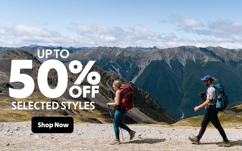 Two people hiking with mountains in the background and promotional text overlay.