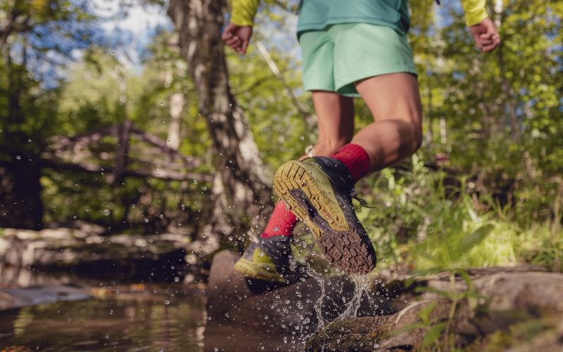 Person running through a stream in a forest